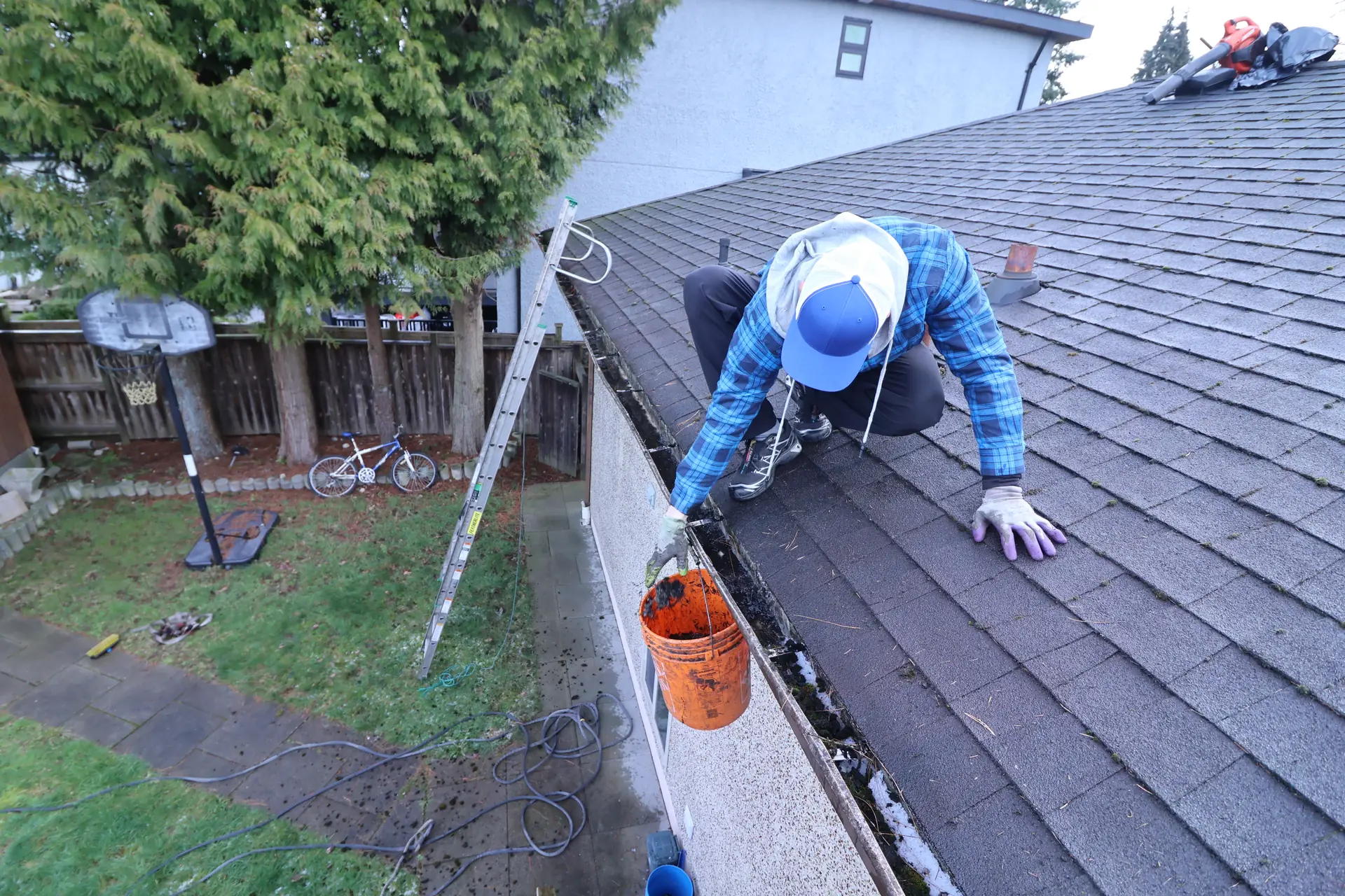 Contractor clearing gutters from the roof